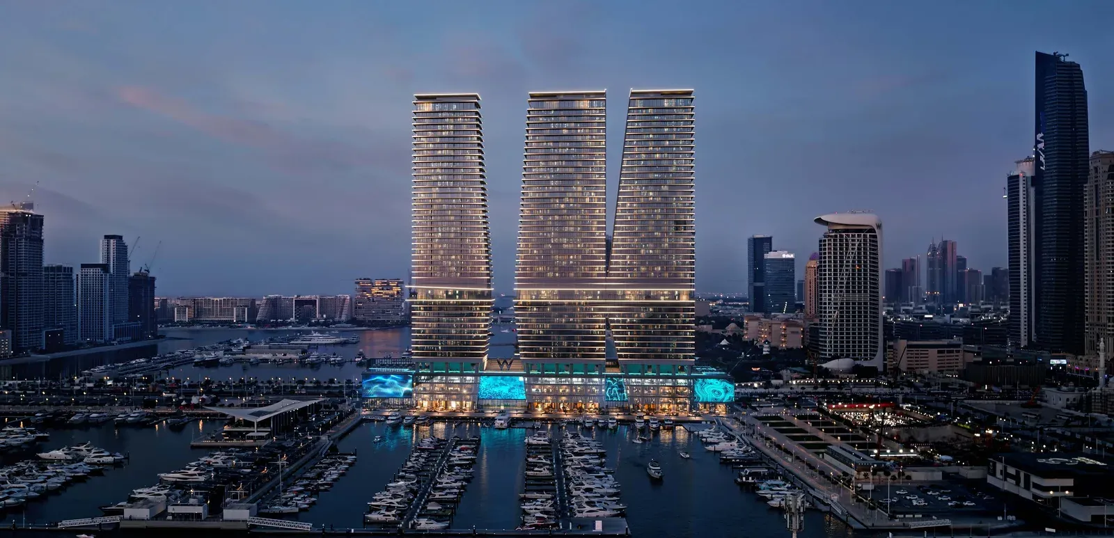 W Residences at Dubai Harbour — three towers beside the marina at night